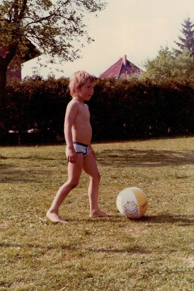 René Müller als kleines Kind mit einem Fußball auf einer Wiese
